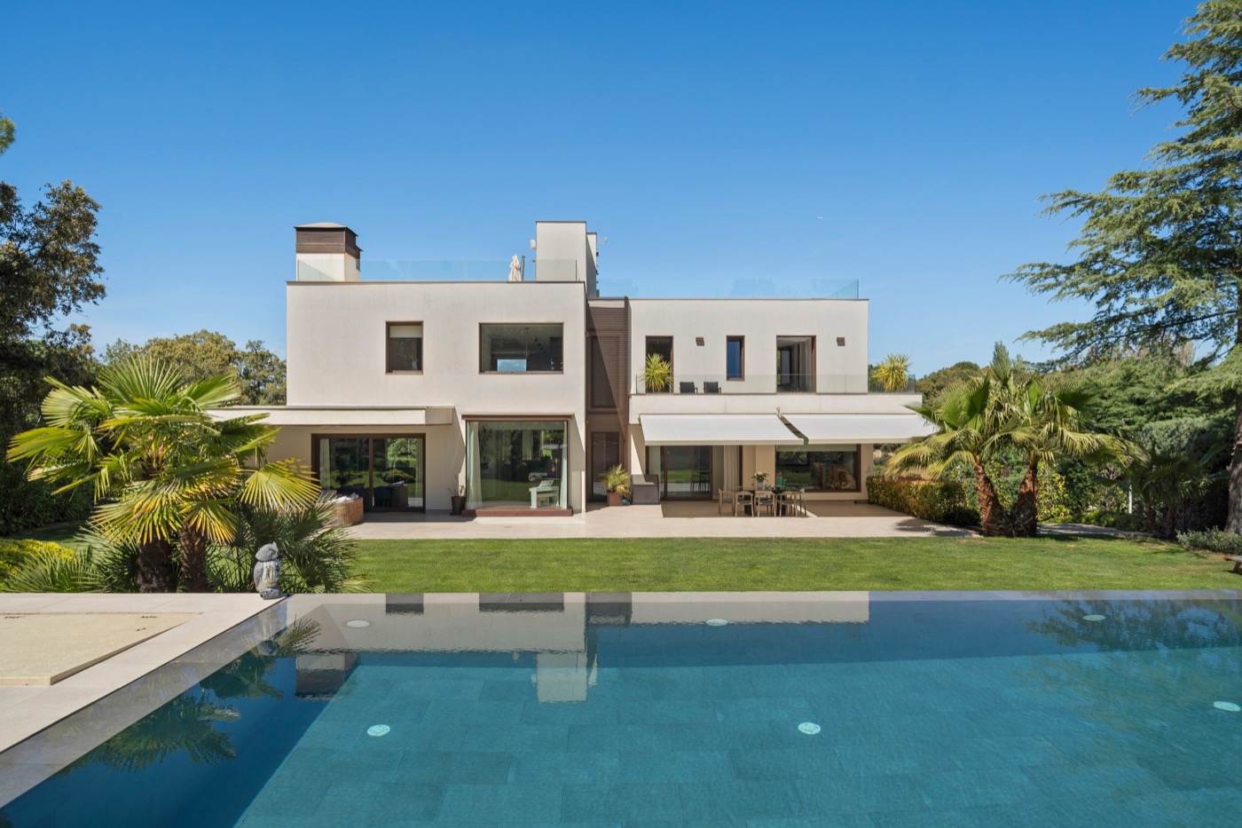 Contemporary villa with palms reflected in the pool